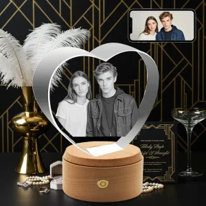 A heart-shaped 3D photo crystal engraved with a stylish young couple's portrait, displayed as a chic wedding gift amidst a glamorous Art Deco setting.