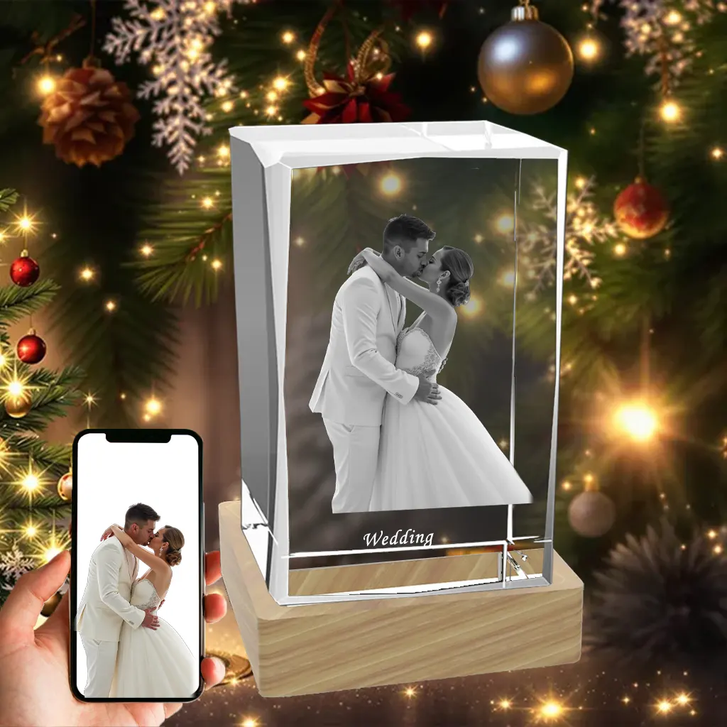 A rectangular 3D photo crystal engraved with a kissing wedding couple, displayed as a Christmas gift in front of a festive Christmas tree.