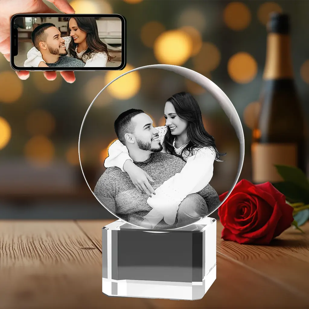 A 3D photo crystal ball engraved with a romantic couple's portrait, resting on a solid, engravable crystal base, as a heartfelt anniversary gift.