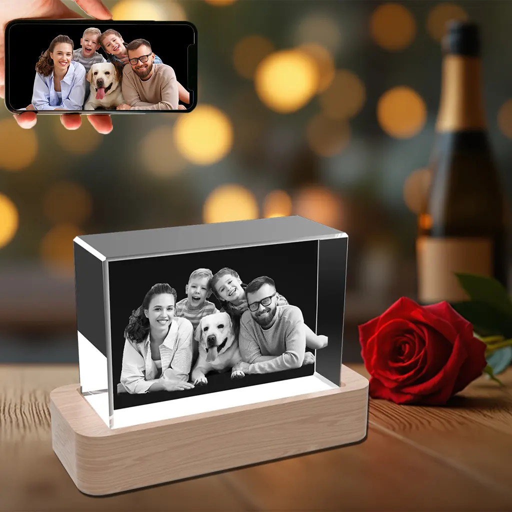 A horizontal 3D crystal block engraved with a warm family portrait including parents, two children, and their dog, resting on an illuminated wooden base.