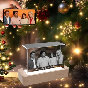 A horizontal 3D photo crystal engraved with a picture of four friends and "Friendship Lasts Forever," displayed as a Christmas gift in front of a festive tree.