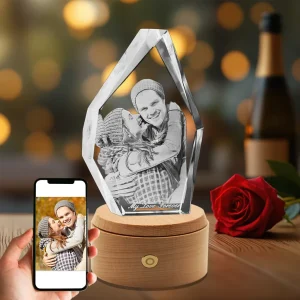 A unique iceberg-shaped 3D photo crystal, engraved with a sweet couple's portrait and the text "My Love Forever," set on a luminous rotating wood base as a special anniversary gift.