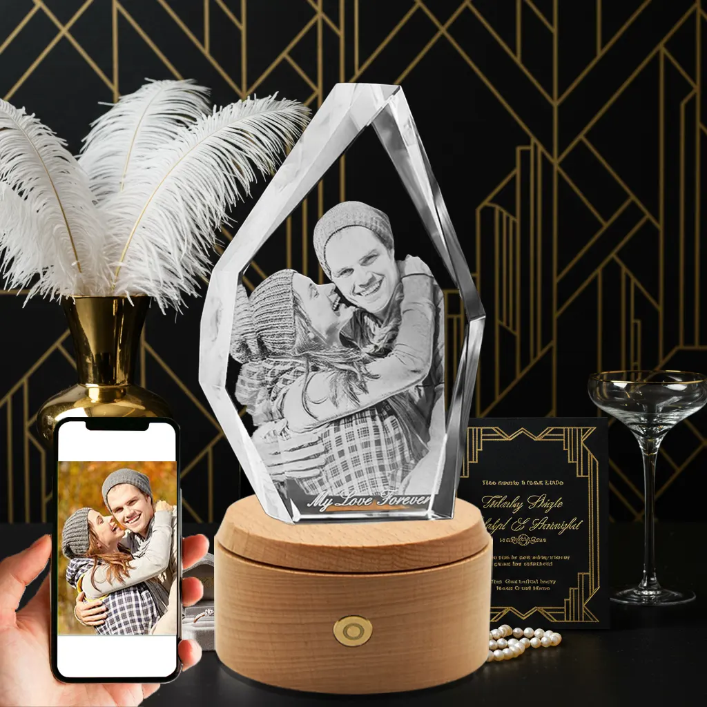 A 3D photo of a happy couple in winter hats is engraved in an iceberg-shaped crystal with "My Love Forever" text. The crystal is on a wooden rotating LED base, with a phone showing the original color photo, set against an elegant art deco wedding-themed background.