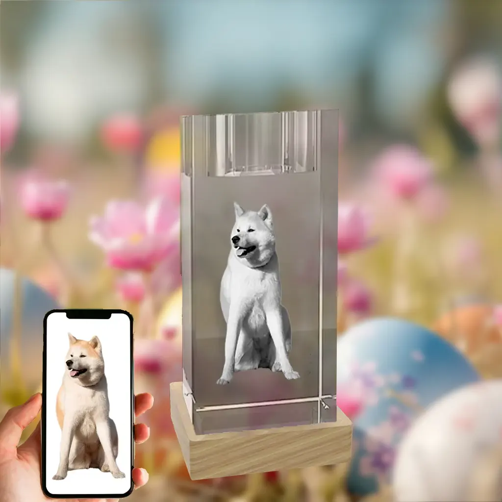 A 3D photo of a white Akita dog is engraved inside a crystal candle holder on a wooden base. It's set against a festive Easter background of flowers and eggs, with a hand holding a phone showing the dog's original color photo.