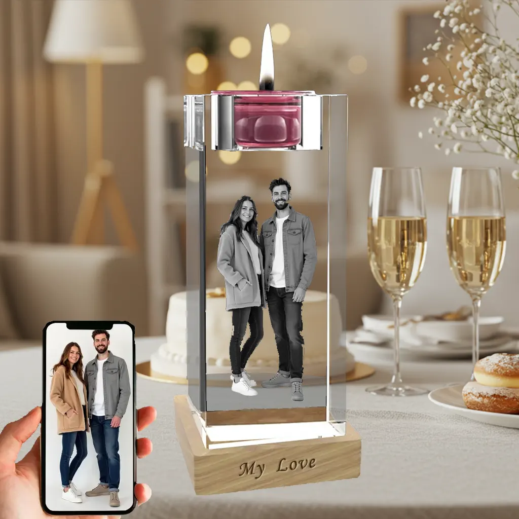 A personalized 3D photo of a couple is engraved inside a crystal candlestick, which sits on an illuminated wooden base. The original photo is shown on a phone, with a celebratory background of champagne and cake for a baptism occasion.