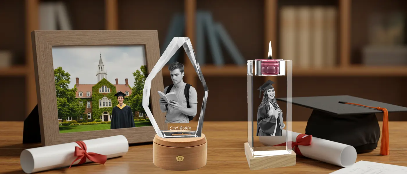 A commemorative display of personalized 3D photo crystal graduation gifts, set on a scholarly desk alongside a graduation cap, diplomas, and a university photo frame.