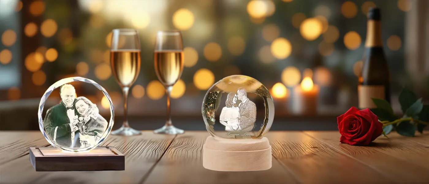 A romantic anniversary celebration setting featuring two personalized 3D photo crystal gifts on a wooden table, alongside two glasses of champagne, a red rose, and warm candlelights in the background.