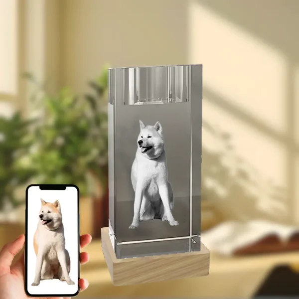 A YiYues personalized 3D crystal candle holder with a custom 3D photo of a dog, on a wooden base. A hand holds a smartphone showing the original color photo, demonstrating the customization process.