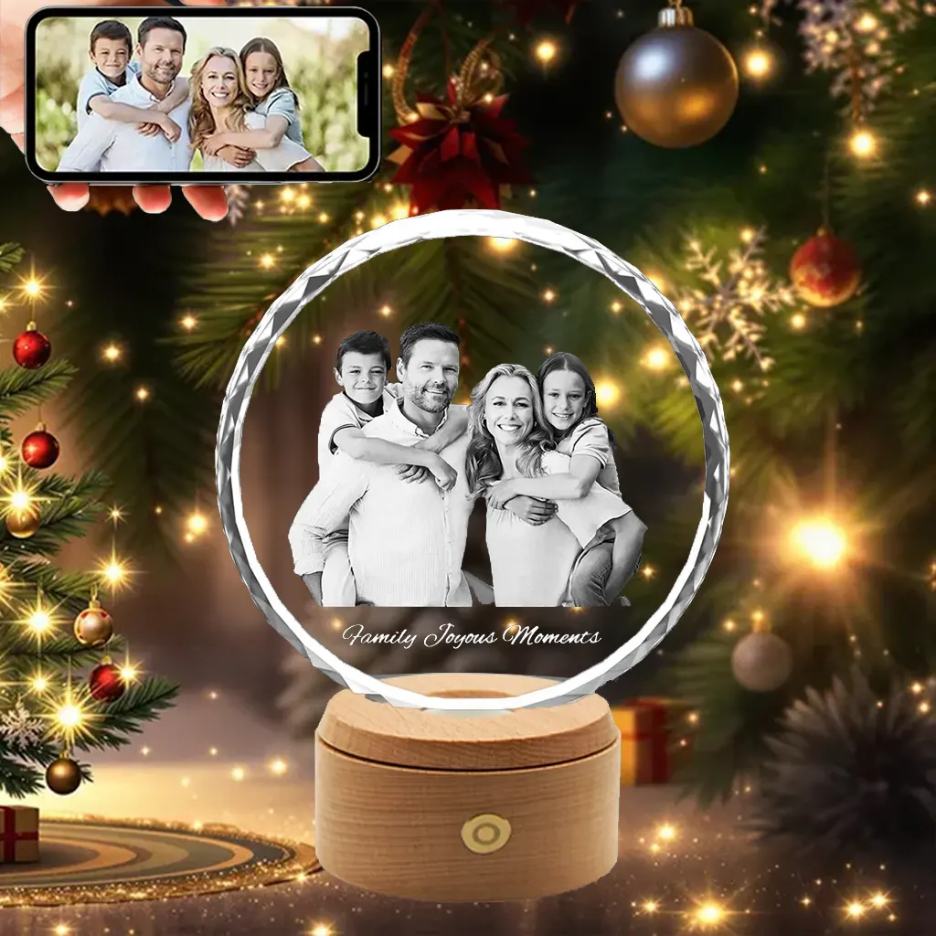 YiYues 3D Crystal A round, sunflower-faceted 3D photo crystal engraved with a happy family of four and the text "Family Joyous Moments," displayed on an illuminated rotating wooden base.