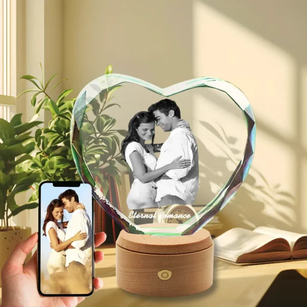 YiYues Faceted 3D Heart Shaped Crystal displaying a prismatic rainbow effect in sunlight, featuring a custom photo of a couple on a wooden LED base in a beautiful home setting.